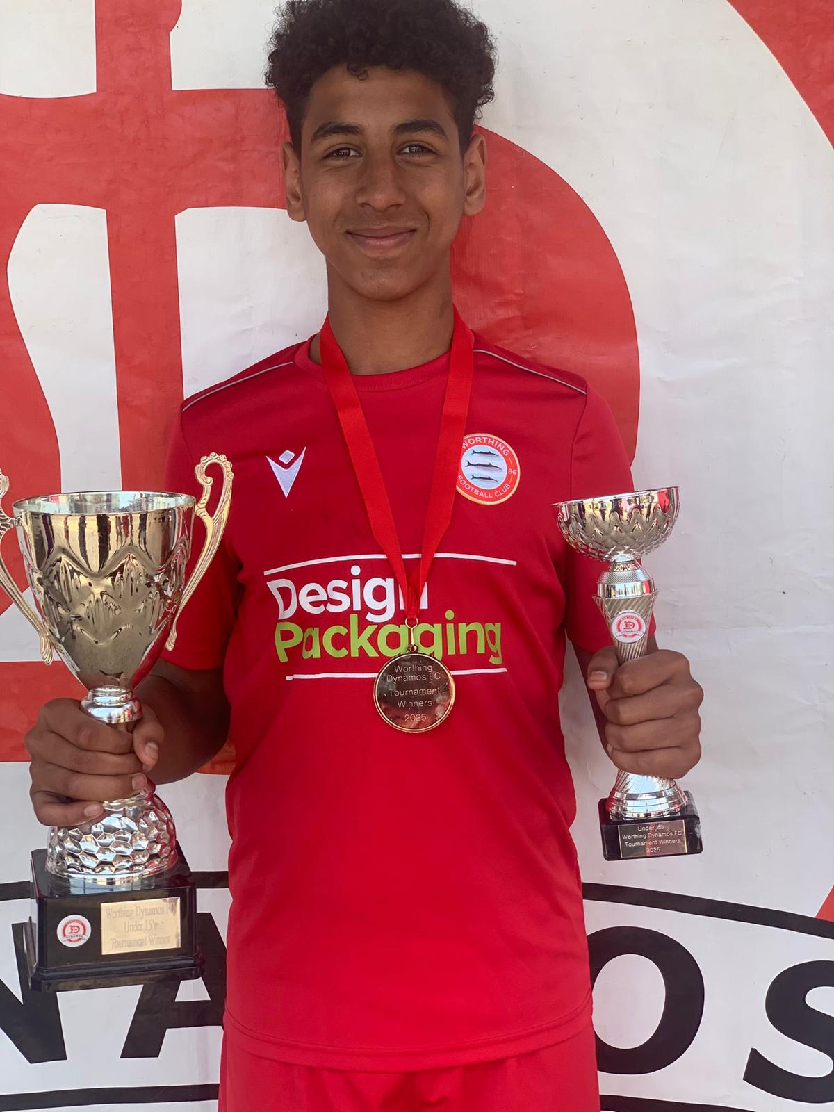 Footballer holding tournament trophies
